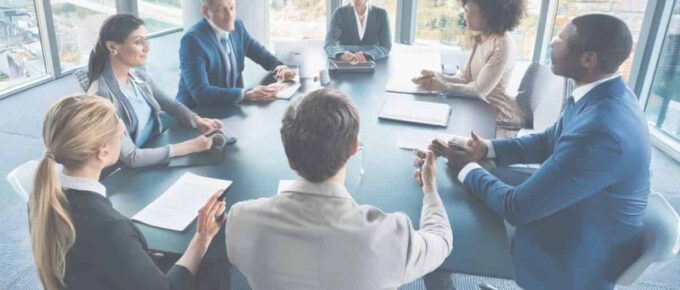 How to have an effective Small Business Meeting - square image with people sitting around a table.