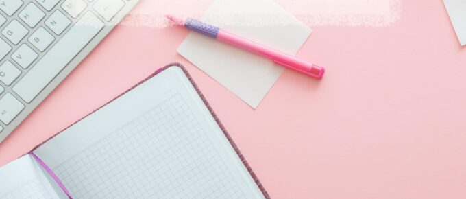 square image with the title at the top center with pink background and note pad at the bottom left and keyboard at the top left and pen