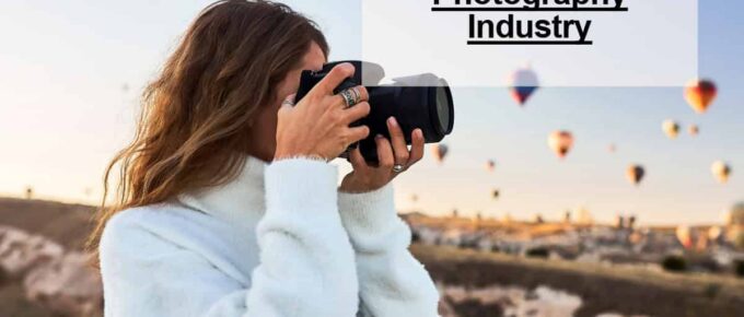 square image - title of post at the top right - a person with a camera taking a picture of hot-air balloons - logo at the bottom right